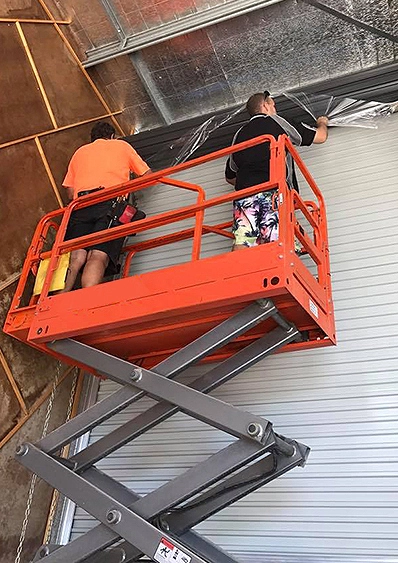 Men install large commercial roller door warehouse Townsville